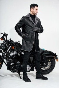 Close-up of black PU leather jacket with grey faux fur collar on male model