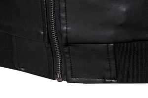 Detailed close-up of metal zipper and ribbed hem on a black PU leather jacket