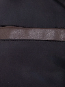 Dettaglio di tessuto in nylon ad alta densità e cuciture in pelle marrone con doppie cuciture