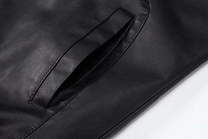 Close-up detail of pocket stitching and lychee grain texture on black faux leather jacket