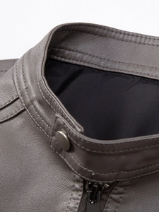Detail of stand collar on dark brown PU leather jacket with silver button and zipper