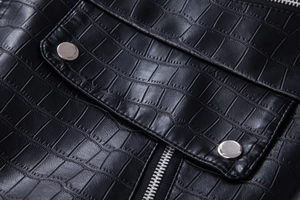 Detailed macro view of crocodile texture faux leather with silver snap button and zipper
