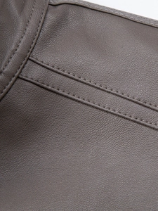 Close-up of brown PU leather jacket with premium litchi grain and durable double stitching