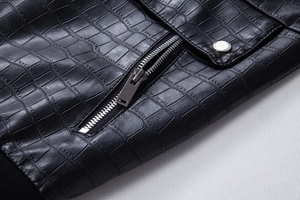 Detail of black faux leather jacket with crocodile texture and silver metal zipper