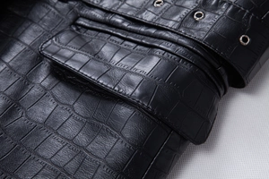 Detail of black crocodile texture faux leather jacket with metal eyelet belt and pocket flap