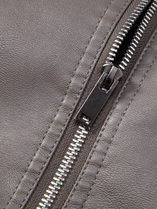 Detailed macro of dark gray faux leather jacket with metal zipper and pebble grain texture