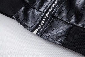 Macro view of black embossed faux leather jacket texture with silver metal zipper detail