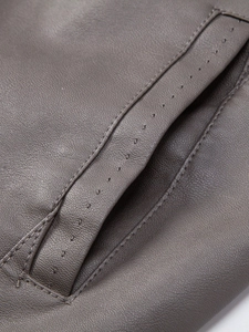 Detailed macro shot of fine grain texture and precision stitching on men leather jacket