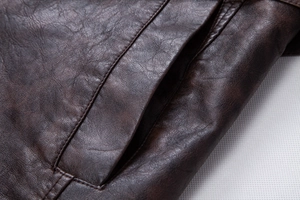 Close-up of side pocket on brown PU leather jacket showing detailed double stitching