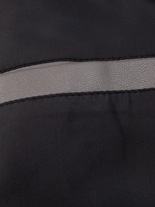 Close-up of black PU leather jacket fabric with grey decorative strap and double stitching