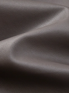 Close-up detail of premium dark brown PU leather showing natural pebble grain texture