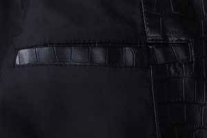 Detailed close-up of black PU leather jacket with faux crocodile skin texture on pockets