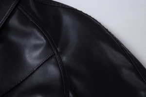 Close-up of black PU leather jacket showing fine grain texture and neat stitching on shoulder