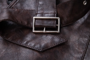 Close-up detail of dark brown distressed leather jacket with metallic buckle and stitching