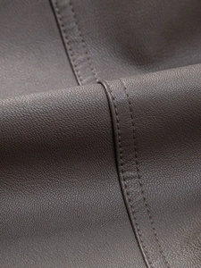 Detailed view of dark brown PU leather jacket with premium stitching and fine texture