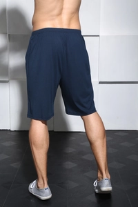 Rear view of men's loose navy blue casual shorts with elastic waistband on a model