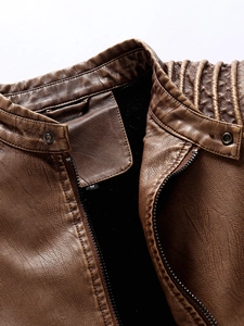 Detail view of brown PU leather jacket with quilted shoulder stitching and metal zipper