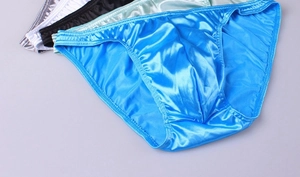 Detailed view of high-gloss satin men's briefs featuring smooth textures in multiple colors