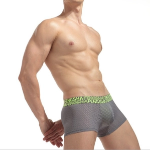 Détail du tissu en maille respirant et de la ceinture vert néon du boxer gris pour homme