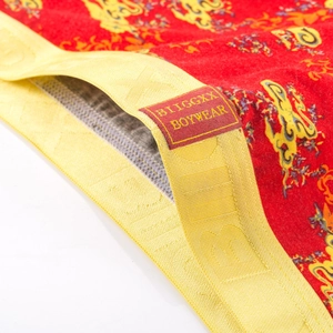 Detail der roten Herrenboxershorts mit Drachendruck und gelbem Logo-Elastikbund