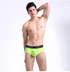 Detail of neon green men's underwear with black wide elastic waistband and lettering
