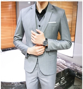 Detail of slim fit grey 3-piece suit with notch lapel, vest, and four-button cuff decoration