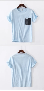 Macro detail of men's blue crew neck T-shirt featuring a contrast grey pocket with STYLE label