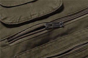 Detail view of military green utility vest showing metal zipper and durable pocket flap