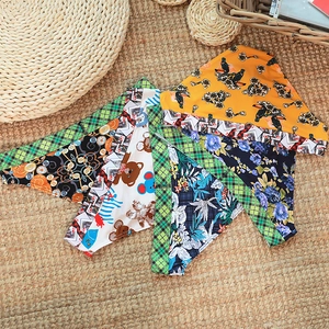 Flat lay of diverse patterned cotton pet bandanas on a textured woven mat background