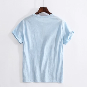 Light blue crew neck t-shirt with rolled sleeves and loose fit in minimalist back view