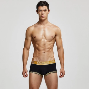 Nahaufnahme schwarzer Herren-Boxershorts mit goldenem Jacquardbund und gestreiften Details