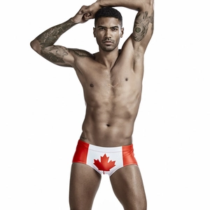 Macro detail of men's swim trunks featuring Canadian flag maple leaf print and red side panels