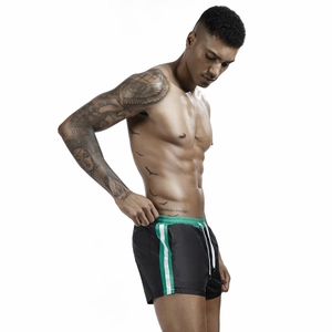 Detail of men's athletic shorts featuring neon green elastic waistband and side stripes