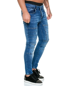Détail du jean motard bleu avec genoux plissés et baskets noires cloutées pour hommes
