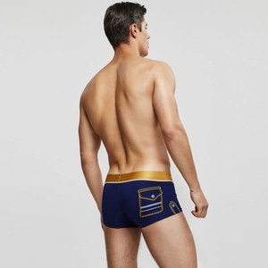 Détail de boxer bleu pour homme avec ceinture dorée et imprimé de poche décorative
