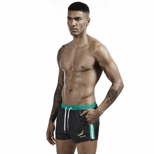 Detail view of men's black sports shorts with mint green waistband and banana print