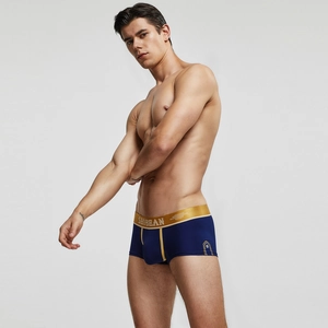 Détail d'un boxer bleu marine pour homme avec ceinture dorée métallique et coupe ajustée