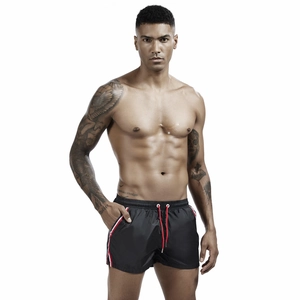 Close-up of men's sports shorts with red drawstring and side stripe detail