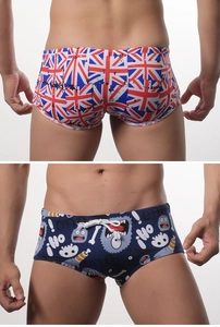 Detail of men's square-leg swim trunks featuring Union Jack and cartoon monster prints