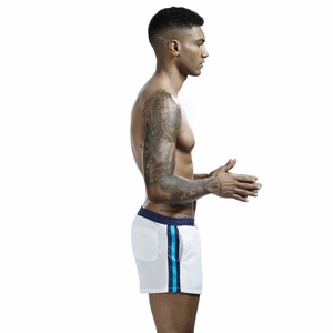 Detail view of white men's athletic shorts featuring side stripes and elastic waistband