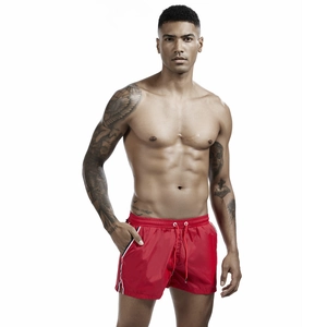 Close-up of red quick-dry swim shorts featuring drawstring waist and tricolor stripe detail