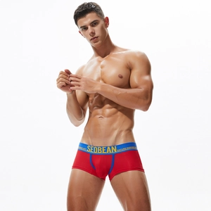 Macro detail of red boxer briefs featuring a blue low-waist band with brand lettering