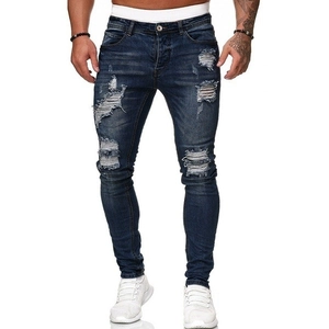 Dettaglio dei jeans slim fit blu con strappi sulle ginocchia e finitura denim lavata a pietra