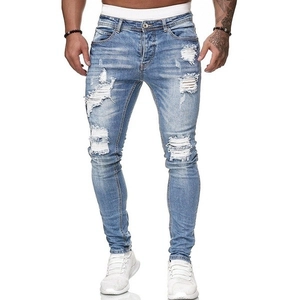 Dettaglio dei jeans skinny da uomo in blu chiaro con ampi strappi ed effetti invecchiati