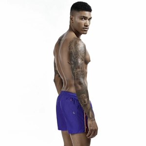 Detail view of royal blue swim trunks featuring side stripes and a functional back pocket