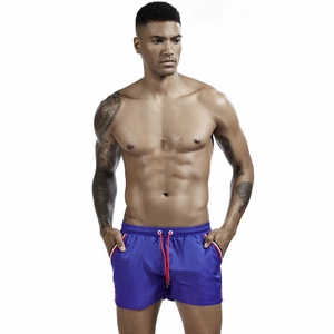 Detail view of men's royal blue sports shorts with red drawstring and side stripes