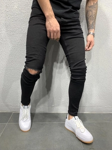 Détail du genou déchiré horizontalement sur le jean skinny noir extensible pour hommes