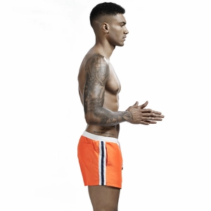 Detailed side view of orange men's athletic shorts featuring navy stripes and drawstring