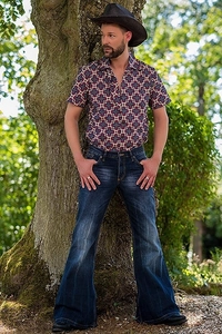 Detailed view of men's vintage flare jeans with wash effect and printed shirt