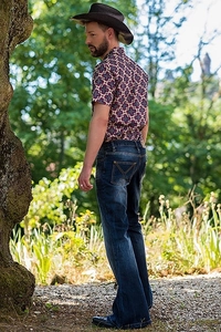 Rear view of flare jeans with yellow stitching details in an outdoor forest setting
